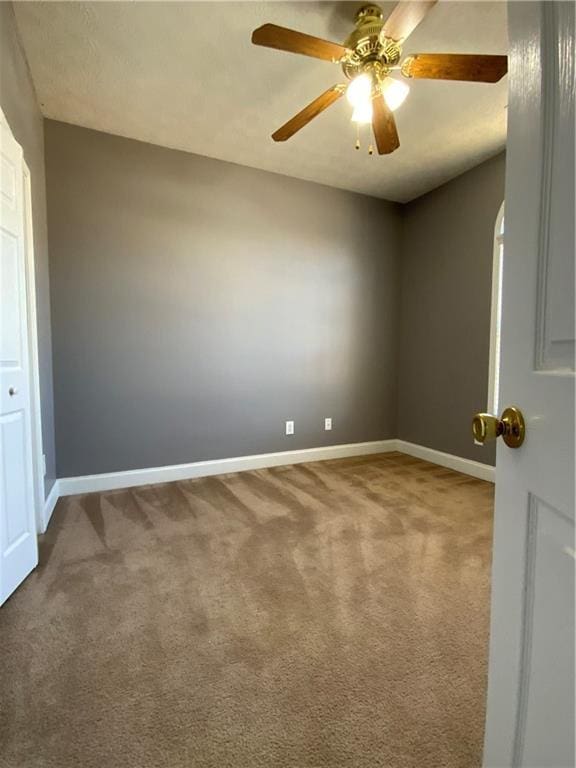 carpeted empty room featuring ceiling fan