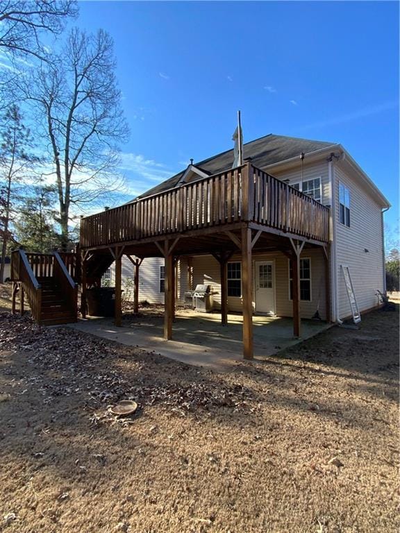 back of property with a wooden deck and a patio