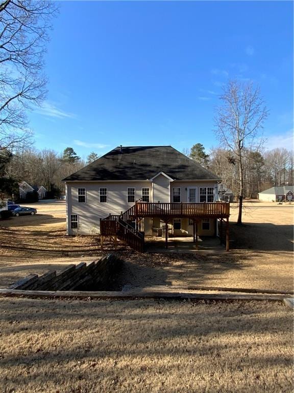 rear view of house with a wooden deck and a yard