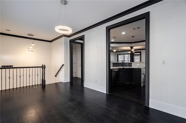 2767 Durham Dr NE, Atlanta, GA 30319 - spare room featuring dark wood-type flooring, crown molding, baseboards, and a sink