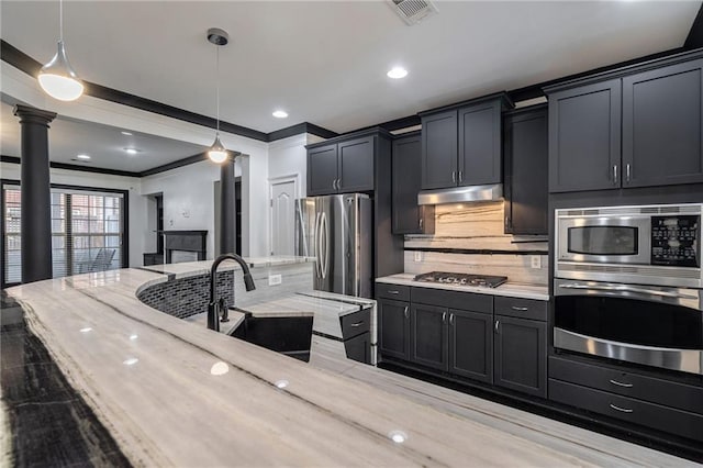 2767 Durham Dr NE, Atlanta, GA 30319 - kitchen featuring stainless steel appliances, a sink, under cabinet range hood, pendant lighting, and ornamental molding