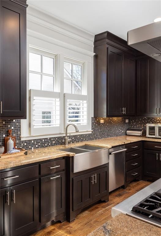 kitchen featuring sink, light hardwood / wood-style flooring, tasteful backsplash, ornamental molding, and stainless steel dishwasher