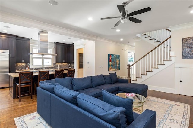 living room featuring crown molding, wood-type flooring, and a wealth of natural light