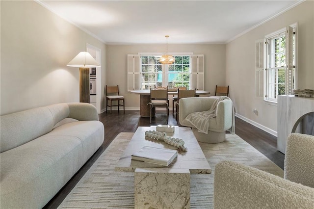 living room with wood finished floors, baseboards, crown molding, and a chandelier