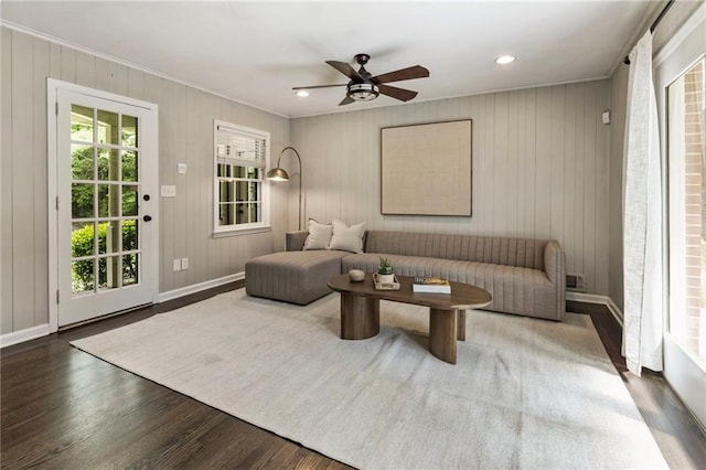 living room featuring ceiling fan, ornamental molding, wood finished floors, and baseboards