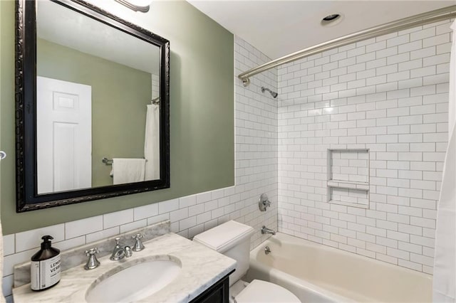 full bathroom with shower / bath combo, vanity, toilet, and tile walls