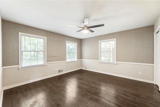 unfurnished room with ceiling fan, dark wood-style floors, and baseboards