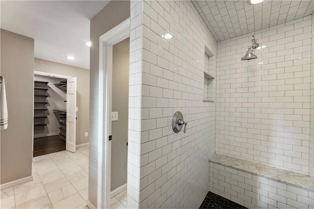 full bath with tiled shower, recessed lighting, a spacious closet, and baseboards