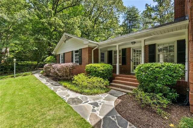 ranch-style house with brick siding, a front lawn, and covered porch