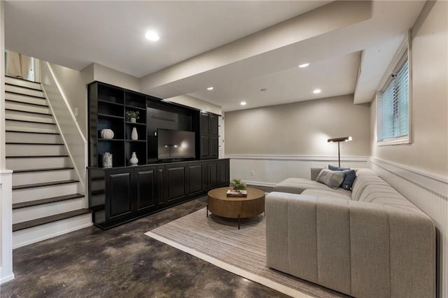 living room featuring stairway, concrete flooring, a wainscoted wall, and recessed lighting