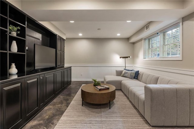 living room with wainscoting, concrete flooring, and recessed lighting