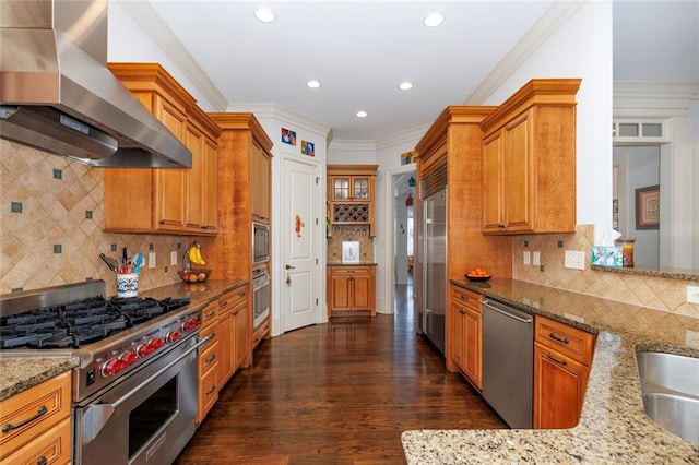 kitchen with premium appliances, light stone counters, ornamental molding, dark wood-type flooring, and extractor fan