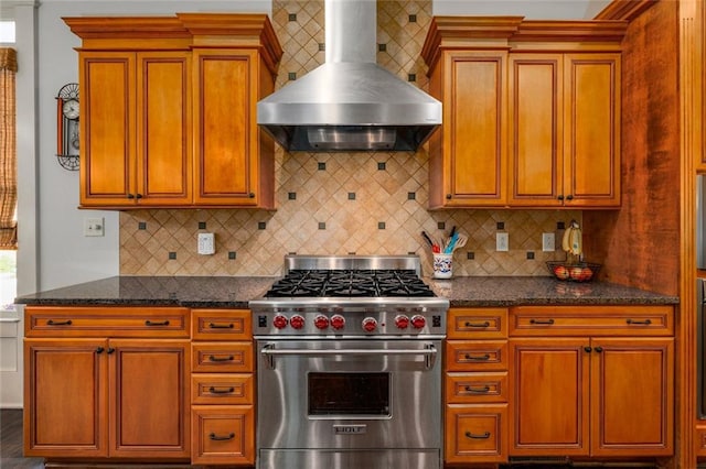 kitchen with dark stone counters, ventilation hood, backsplash, and luxury stove