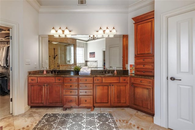 full bath with double vanity, a shower stall, a walk in closet, and crown molding