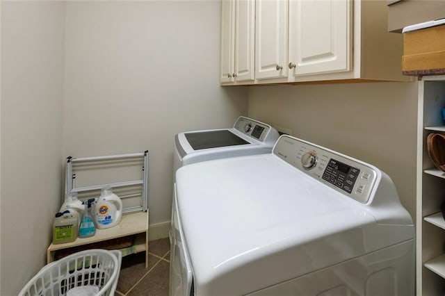 laundry area featuring cabinet space, dark tile patterned flooring, and independent washer and dryer