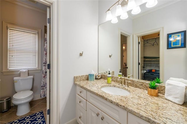 bathroom featuring baseboards, vanity, toilet, and tile patterned floors