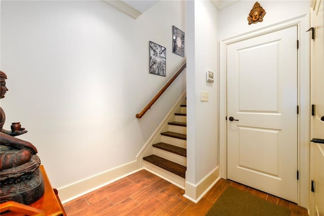 stairway with baseboards and wood finished floors