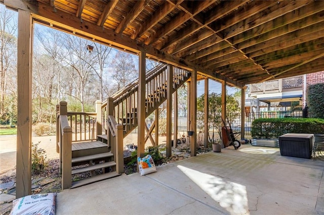 view of patio with fence and stairway