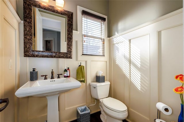 bathroom featuring toilet and a decorative wall