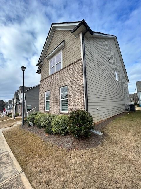 view of property exterior with central AC unit and a yard