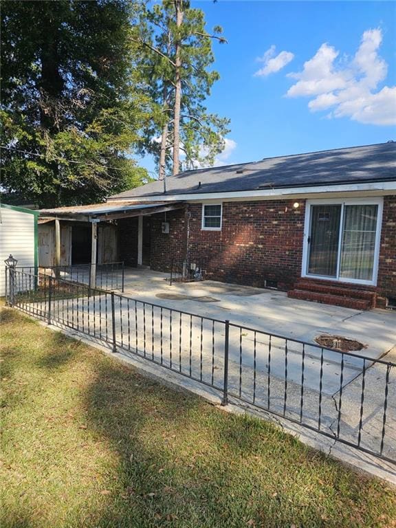 back of house with a patio and a lawn