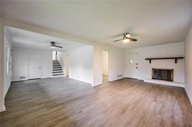 382 Plantation Blvd, Lawrenceville, GA 30046 - unfurnished living room with a ceiling fan, wood finished floors, a brick fireplace, and stairway