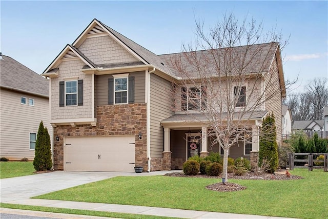 craftsman-style home with driveway, stone siding, fence, a front yard, and a garage