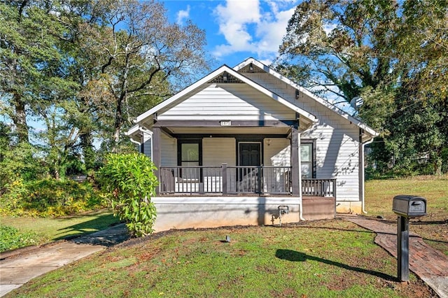 bungalow-style home featuring covered porch and a front lawn