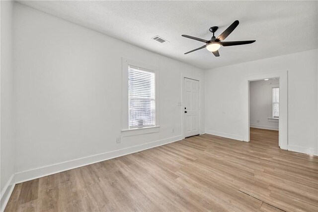 unfurnished room with ceiling fan, light hardwood / wood-style floors, and a textured ceiling