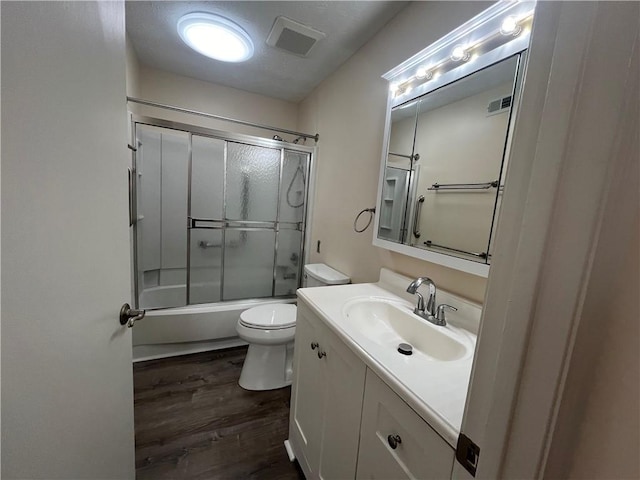 full bath featuring toilet, visible vents, wood finished floors, and vanity