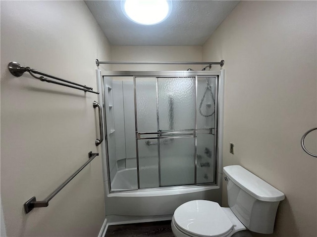 full bathroom with a textured ceiling, shower / bath combination with glass door, wood finished floors, and toilet