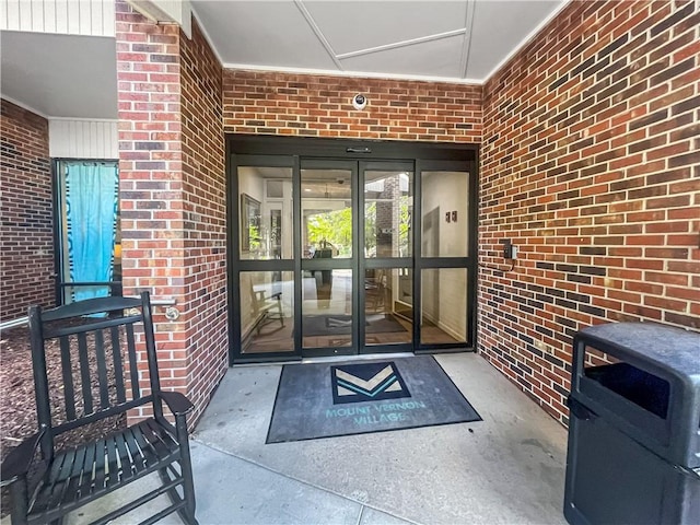 doorway to property featuring brick siding