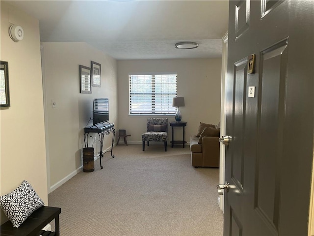 sitting room featuring carpet flooring and baseboards