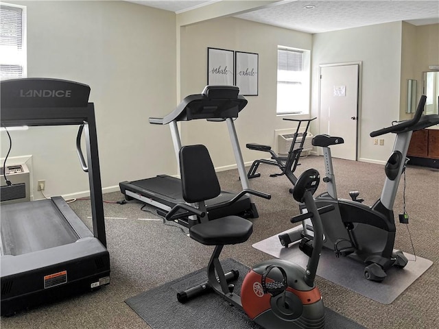 workout area with baseboards and a textured ceiling