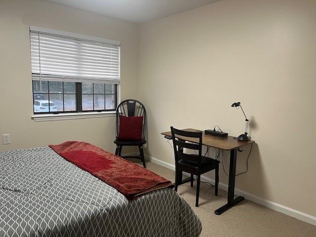 bedroom with light carpet and baseboards