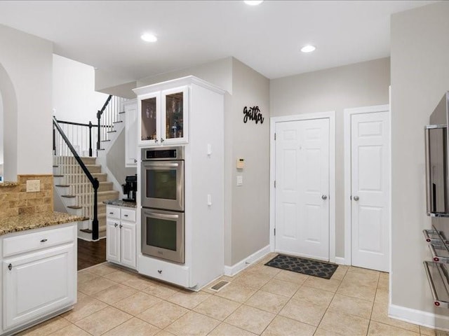 1630 Reindeer Rdg, Alpharetta, GA 30005 - kitchen with double oven, arched walkways, light tile patterned floors, white cabinets, and recessed lighting