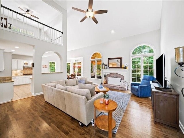 1630 Reindeer Rdg, Alpharetta, GA 30005 - living room with ceiling fan, a towering ceiling, a fireplace with raised hearth, and wood finished floors
