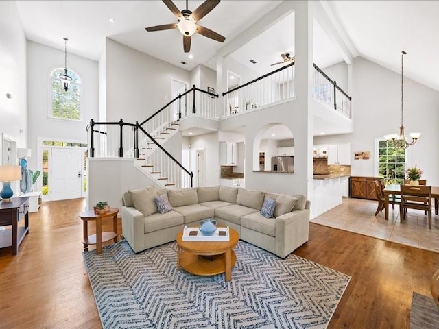 1630 Reindeer Rdg, Alpharetta, GA 30005 - living room with high vaulted ceiling, wood finished floors, a chandelier, a ceiling fan, and stairs