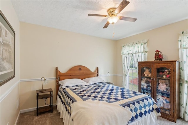 bedroom featuring carpet floors, baseboards, a ceiling fan, and a textured ceiling