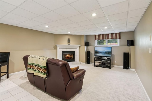 carpeted living room featuring baseboards, a drop ceiling, recessed lighting, and a tile fireplace