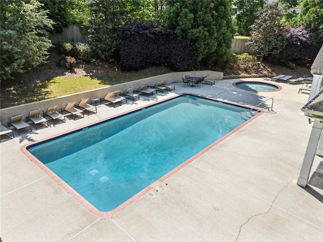 view of pool with a fenced in pool, an in ground hot tub, a patio area, and fence
