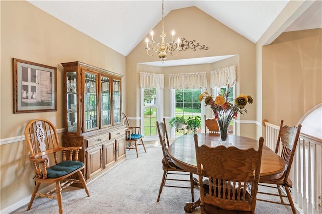 dining room with light colored carpet, high vaulted ceiling, and a chandelier