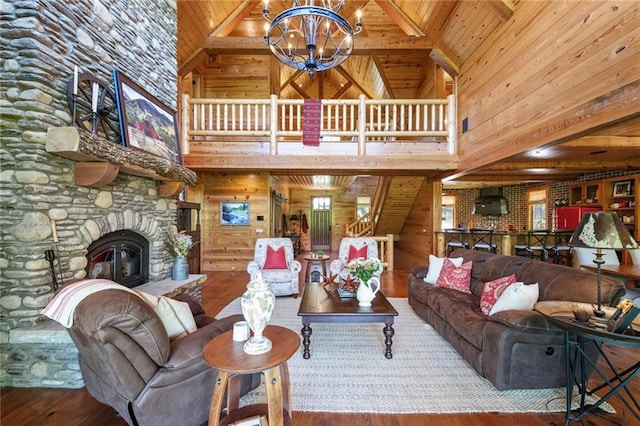 living room with wood-type flooring, high vaulted ceiling, a fireplace, and wooden walls