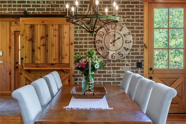 dining space featuring a healthy amount of sunlight and brick wall