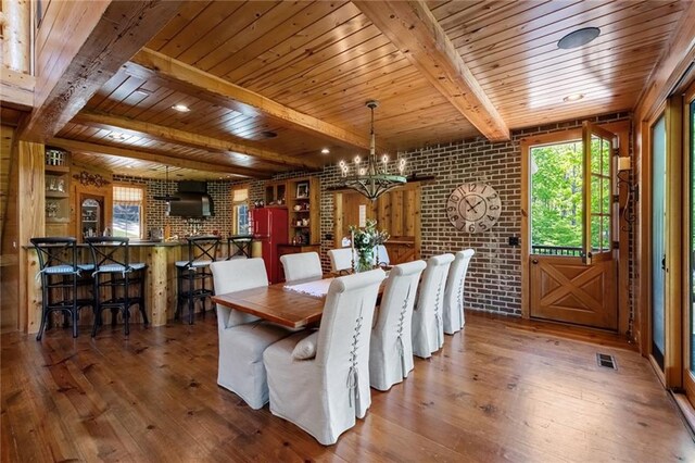 dining room featuring brick wall, an inviting chandelier, hardwood / wood-style floors, and wood ceiling