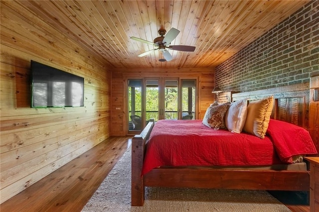 bedroom featuring wooden ceiling, brick wall, wooden walls, and hardwood / wood-style floors