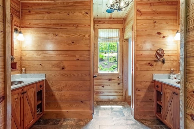 bathroom with tile floors, wood walls, and vanity