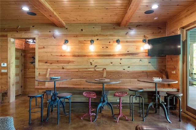 bar with wooden walls, beamed ceiling, and wooden ceiling