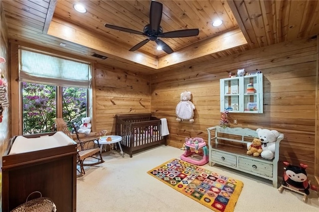 bedroom featuring wooden ceiling, carpet flooring, a crib, and ceiling fan