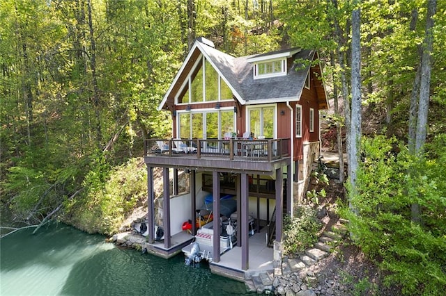 rear view of house with a deck with water view